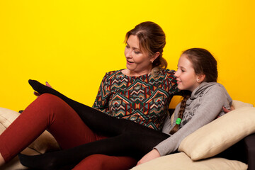 Mom and daughter sit on couch in family love room