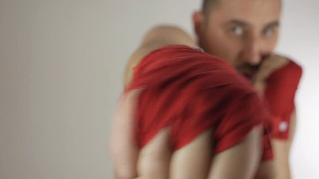 A bald man with a bandage on his hands does exercises and various boxing movements. Sports, boxing