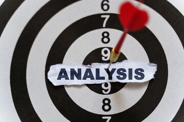 A piece of paper with the text is nailed to the target with a dart - ANALYSIS