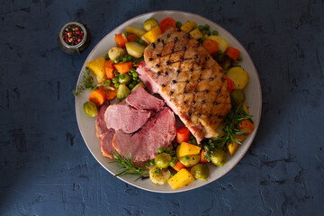 Roasted sliced ham with vegetables. View from above, top studio shot