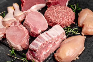 Various types of raw meat of beef, pork, chicken on a stone background