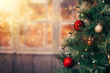 Decorated Christmas tree on blurred background with lights and warm atmosphere.