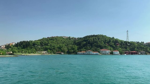 Footage of historical mansions and houses at upscale neighborhood called "Anadolu Hisari" in Istanbul. It is a beautiful Bosphorus scene in a sunny summer day. Camera moves forward.