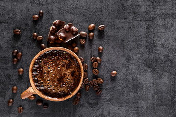 Freshly brewed espresso on a black stone table cup. Roasted arabica and robusta coffee beans.Coffee beans wallpaper.Top view, flat lay with copy space for your text.