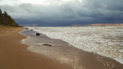 Dramatic stormy dark cloudy sky over sea in sunset time. Weather concept