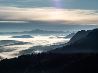 Mountains with trees and fog. Virgin autumnal morning in hilly landscape