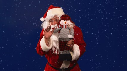 Santa Claus holding a snowman toy plush for Christmas gift in a blue background snowy