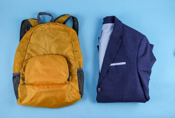 
jacket and backpack.
A man's jacket and a yellow backpack lie in the middle on a blue background, close-up top view.