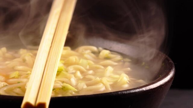 Hot noodle soup with egg and leek.
