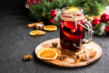 Christmas hot mulled wine with cinnamon cardamom and anise. Dark vintage dirty background. Creative atmospheric decoration