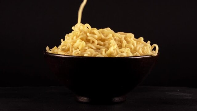 Hand uses chopsticks to pick up chinese noodles.