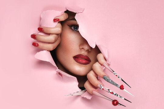 Portrait of a beautiful woman with art make up in glamorous style, creative long nails. Design manicure. Beauty face.