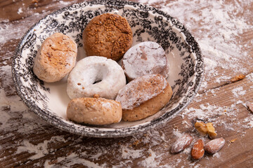 Fototapeta na wymiar plate with powders and shortbreads on wooden table with flour