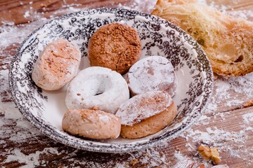plate with powders and shortbreads on wooden table with flour
