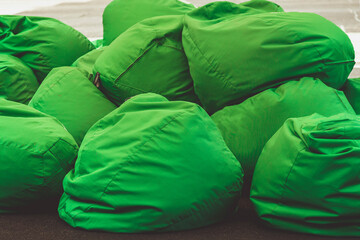 a pile of green bags  chairs. Bean bag chairs