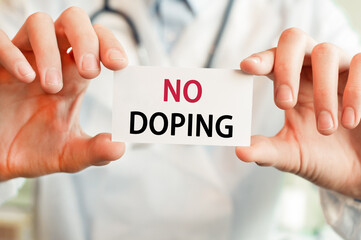 Doctor holding a card with text NO DOPING, medical concept