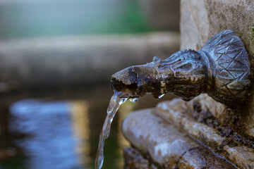 Obraz premium Agua fresa que sale del caño de una antigua fuente de parque
