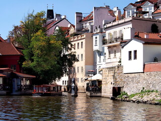 Obraz premium view of Prague from the deck of a steamer, historical city center, panorama on the Vltava, sunny summer day, tourism