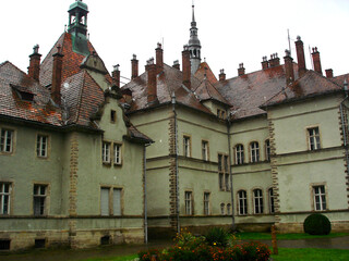 Shenborn Castle building with a flower bed in the courtyard. Wet red tiled roof with turrets at Shenborn Palace
