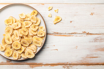 Bowl of Healthy Snack from Banana Chips on Light Wooden Background, vegan, organic, vegetarian healthy alternative crisps