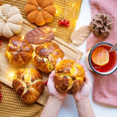 Homemade pumpkin shaped bread located on a dark background.