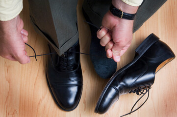 Businessman tying his shoes