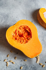 Fresh butternut squash on the grey background. Butternut Pumpkin. Halves of raw orange pumpkin. Contrast photo. Healthy Meal Prep, recipe preparation photos. Seasonal pumpkin