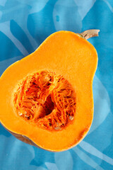 Fresh butternut squash on the grey background. Butternut Pumpkin. Halves of raw orange pumpkin. Contrast photo. Healthy Meal Prep, recipe preparation photo. Seasonal pumpkin cooking