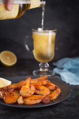 Seafood and a glass of cool foamy beer on the table. Pouring beer into a glass.