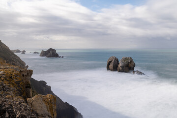 rocky and wild coast with stormy waves hitting the shore