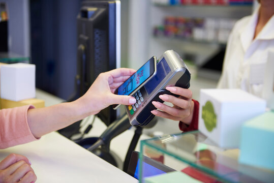 Customer paying cashless with smartphone in a pharmacy