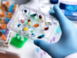 Pharmaceutical Research, Scientist holding a multi well plate containing drugs to be tested in the laboratory