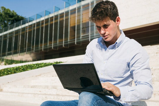Handsome young man using laptop on sunny day