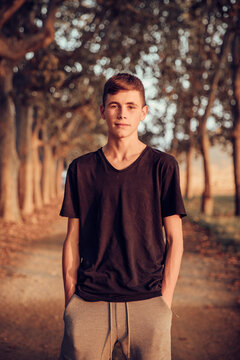 Teenage boy with hands in pockets standing on road