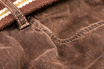 clothing items stonewashed cotton fabric texture with seams, clasps, buttons and rivets, macro