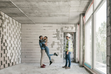 Architect having a meeting with happy future owners on construction site