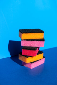 Stack of colorful cleaning sponge on blue background
