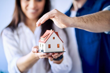 Close-up of couple holding model of new home