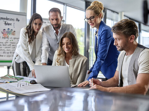 Business people having a workshop sharing laptop