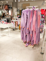 Clothes hanging on a shelf in a clothes store