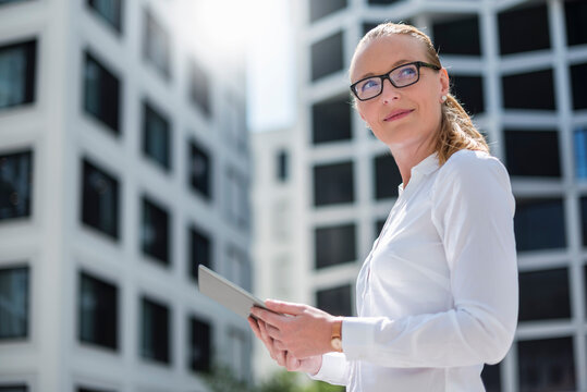 Portrait of businesswoman with tablet outdoors