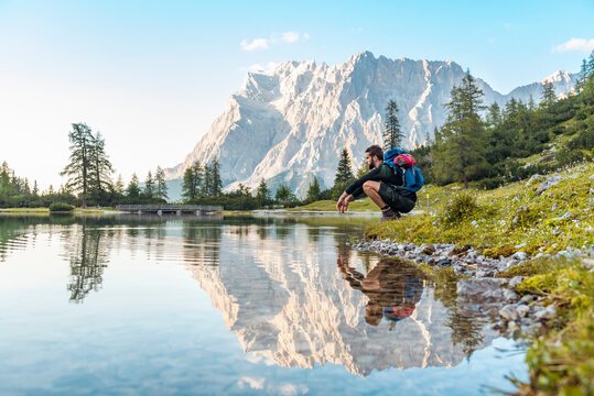 Austria, Tyrol, Hiker taking a break, crouching by the lake