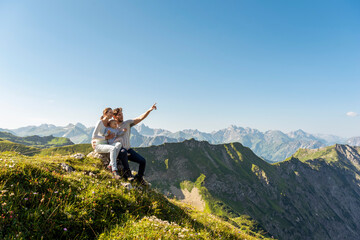Germany, Bavaria, Oberstdorf, family with little daughter on a hike in the mountains having a break looking at view