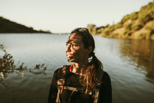 Woman trekking by river across Sierra Morena mountain at Sierra De Hornachuelos, Cordoba, Spain