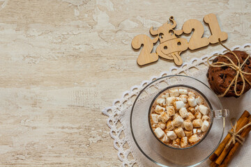 Cup of hot chocolate with marshmallows, cinnamon and anise on wooden background.