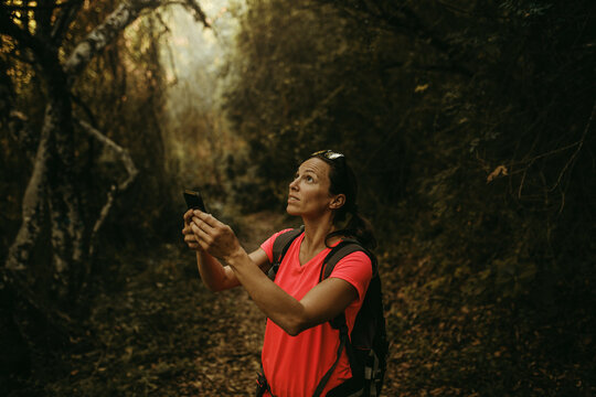 Woman holding mobile phone while standing at Sierra De Hornachuelos, Cordoba, Spain
