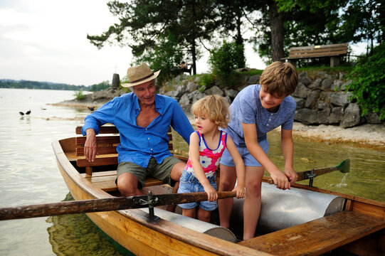 Germany, Bavaria, Murnau, grandfather with grandson and granddaughter in rowing boat