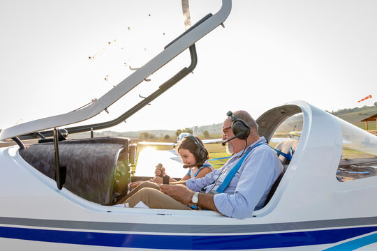 Granddaughter and grandfather getting ready to take off airplane on sunny day