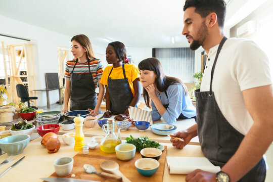 Friends in a cooking workshop watching attentively