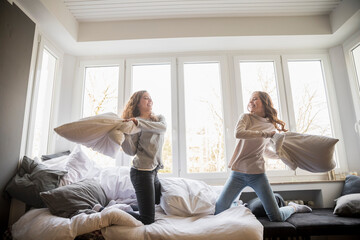 Pillow fight between two best friends at home